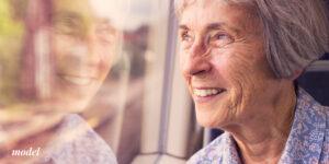 Older Female Considering Dental Implants Looking Out Window